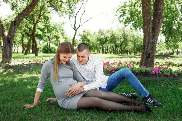Счастливая беременная супружеская пара в парке. В ожидании чуда, ребенка. Семейная жизнь, дети, беременность, семья, отец, мать
. - Фото, изображение