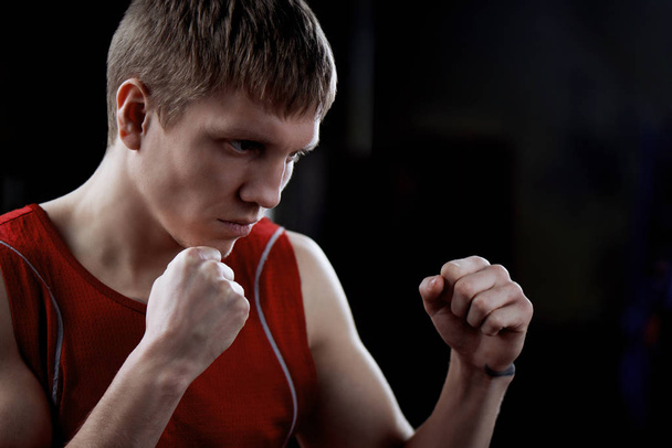 side view of blond fighter standing in boxing pose on grey background  - Photo, Image