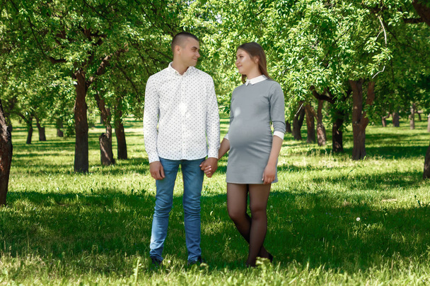 Happy pregnant, married couple in the park. In anticipation of a miracle, a child. Family life, children, pregnancy, family, father, mother. - Fotó, kép