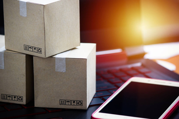 Online vásárlás koncepció e-kereskedelmi szállítási szolgáltatást vásárol. Vásárlás a laptop billentyűzet, vevői rendelés az interneten, és a smartphone Square dobozok. - Fotó, kép