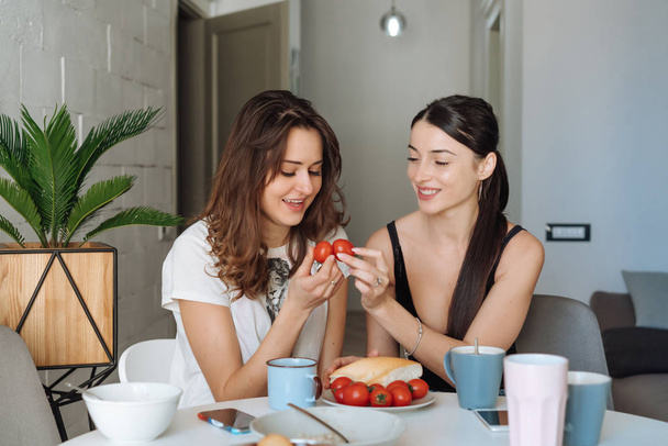 Két nő barát reggeli a konyhában - Fotó, kép