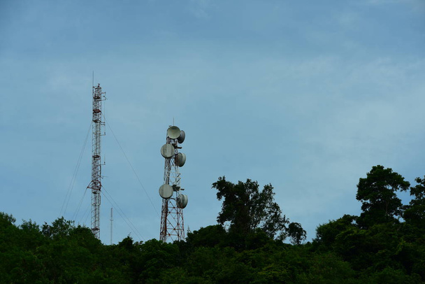 Telefon komórkowy antenowy telewizji satelitarnej higth nad tower. Telefon wieża, komunikacji wieży anteny z blue sky i chmury. - Zdjęcie, obraz