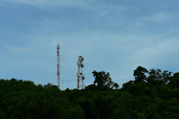 Matkapuhelin atenna Satelliitti higth yläpuolella torni.Puhelin torni, viestintä torni antenni sininen taivas ja pilvet
. - Valokuva, kuva