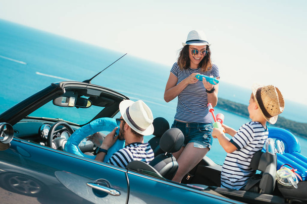 Gelukkige familie reis per auto naar de zee. Mensen met plezier in cabriolet. Zomer vakantie concept - Foto, afbeelding