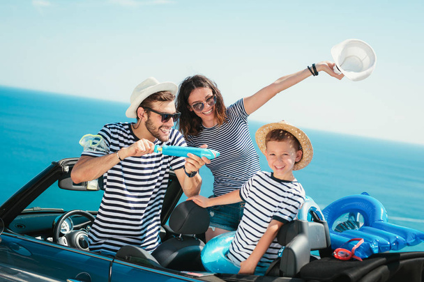 幸せな家族は、海に車で旅行します。カブリオレの楽しみを持つ人。夏の休暇の概念 - 写真・画像
