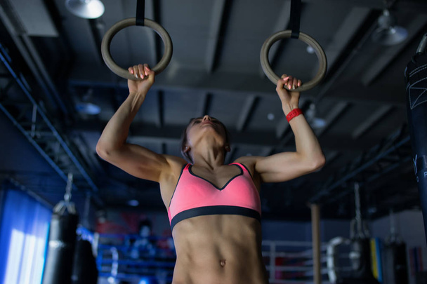 Young woman doing a pullup ongymnastic rings, in the gym - Foto, Imagem