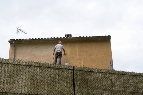 man paints wall of house in french provence area near manosque - Foto, Imagem