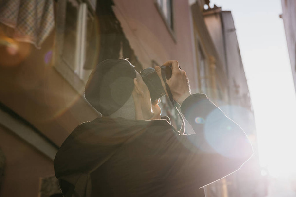 Уличный фотограф или молодой человек фотографирует подлинные дома в Лиссабоне в Португалии. Профессиональный фотограф или турист, фотографирующий на память
 - Фото, изображение