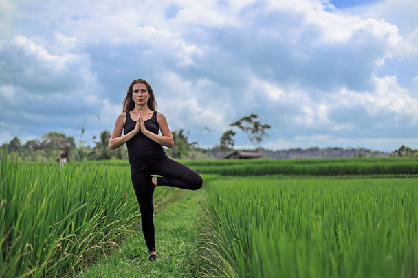 Młoda kobieta praktyki jogi odkryty w pól ryżowych rano podczas odnowy biologicznej retreat w Bali - Zdjęcie, obraz