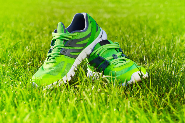 Da vicino nuove paia di scarpe da corsa / scarpe da ginnastica verdi sul campo in erba verde nel parco. Con spazio per testo o design
 - Foto, immagini