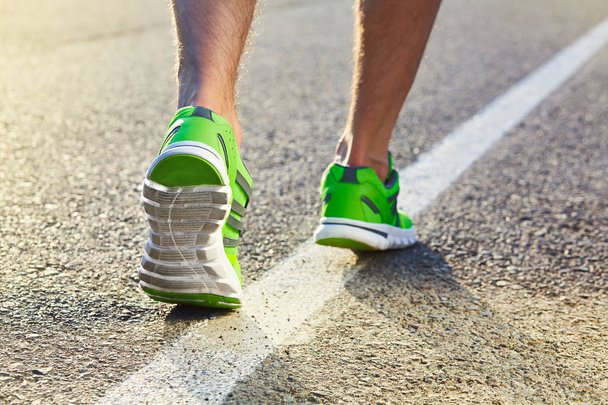 Coureur homme pieds courir sur la route gros plan sur la chaussure. Athlète de fitness masculin jogger séance d'entraînement dans le concept de bien-être. Athlètes masculins en chaussures de course. Jogging
 - Photo, image
