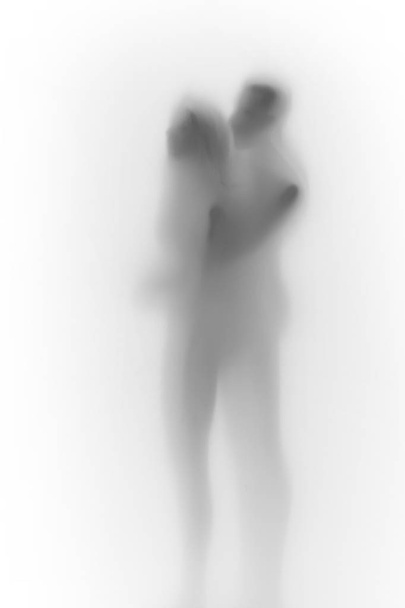 Beautiful couple together hug each-other, body silhouette behind a white curtain - Фото, изображение
