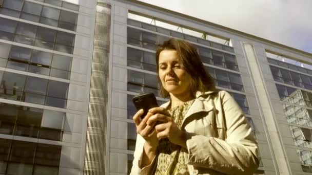 Feliz mujer de negocios riendo por teléfono hablando frente al edificio de oficinas  - Imágenes, Vídeo