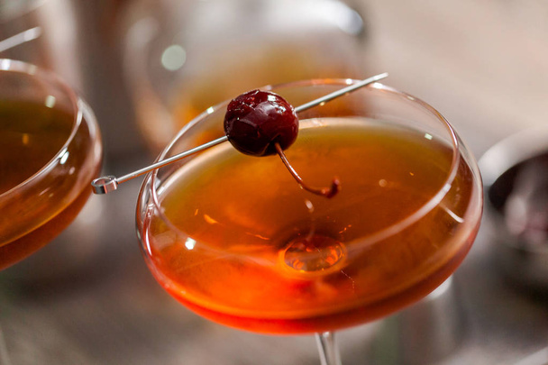 Koktajl Manhattan przyozdobionym z brandied cherry. - Zdjęcie, obraz