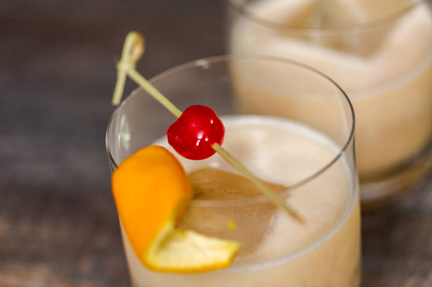 Whisky sour koktajl przyozdobionym z orange i wiśnia. - Zdjęcie, obraz