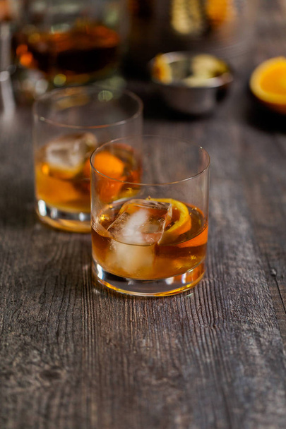 Bourbon oude ouderwets cocktail gegarneerd met sinaasappelschillen. - Foto, afbeelding