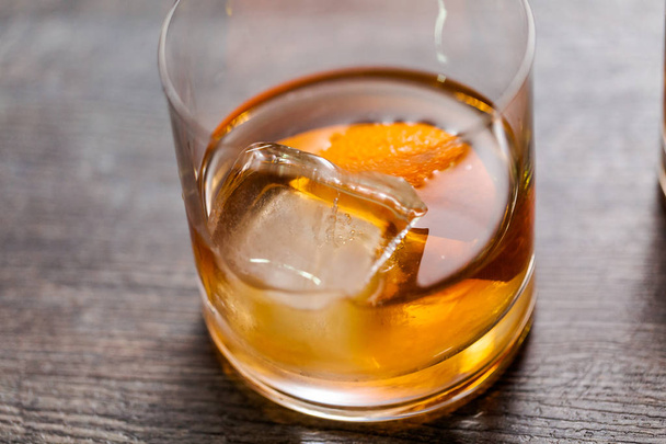 Bourbon old fashioned cocktail garnished with orange peel. - Fotó, kép