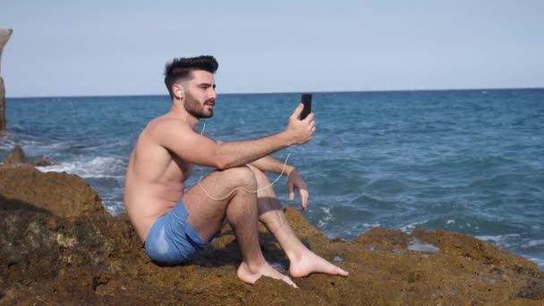 Handsome man doing videochat at sea - Felvétel, videó