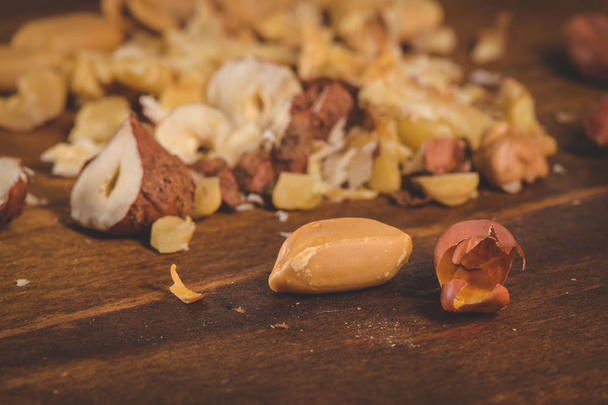 Walnoten, hazelnoten, pinda's en noten op houten tafel. - Foto, afbeelding