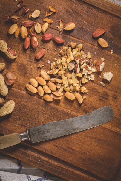 Walnuts, hazelnuts, peanuts and nuts on wooden table. - Valokuva, kuva
