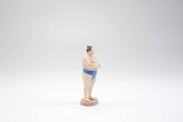 a figure of Sumo wrestler in traditional rack - Photo, Image