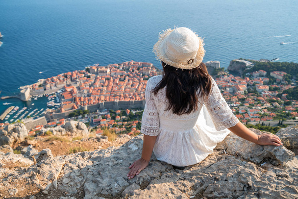 Traveller looking at view of Dubrovnik city, in Dalmatia, Croatia, the prominent travel destination of Croatia. Dubrovnik old town was listed as UNESCO World Heritage Sites in 1979. - Foto, Imagen