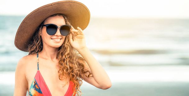 熱帯のビーチでの休暇旅行のための夏で良い時間を過ごして水着を着て幸せな若い女. - 写真・画像
