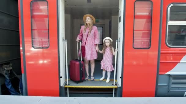 Mladá žena s kufrem a její malá dcera odjíždí vlak do auta - Záběry, video