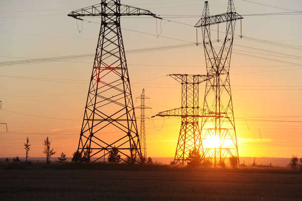 Yüksek gerilim enerji nakil hattı. Enerji ayağı. Gün batımı, şafakta. Elektrik - Fotoğraf, Görsel