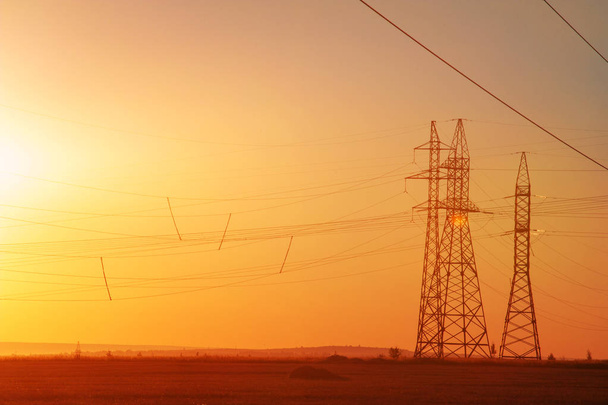 Yüksek gerilim enerji nakil hattı. Enerji ayağı. Gün batımı, şafakta. Elektrik - Fotoğraf, Görsel