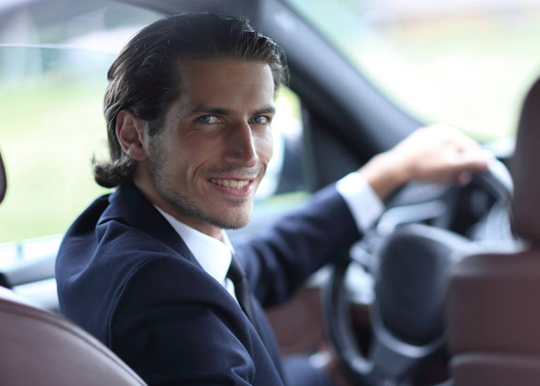 man sitting behind the wheel of a car - Фото, изображение