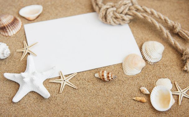 concepto de playa de vacaciones con conchas, costas y postal en blanco
 - Foto, Imagen
