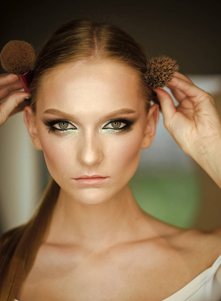 fashion portrait of a sensual sexy girl. Woman with blond hair and makeup brushes, beauty. Woman with makeup face hold brushes at head. Girl with young skin face, skincare, youth. Beauty model with - Foto, afbeelding