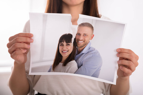 Close-up Of A Woman's Hand Tearing Photo Of Happy Couple - Photo, image