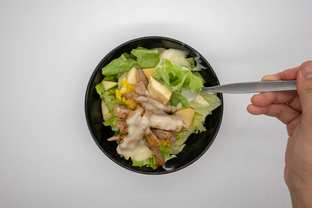 Hand pouring salad cream in dressing on top of homemade grilled pork with organic green vegetable isolated on white background. - Photo, Image