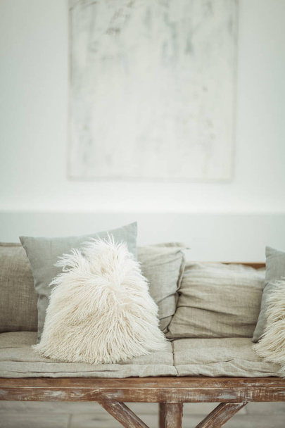 A self-made sofa with light soft pillows in a light-white interior - 写真・画像