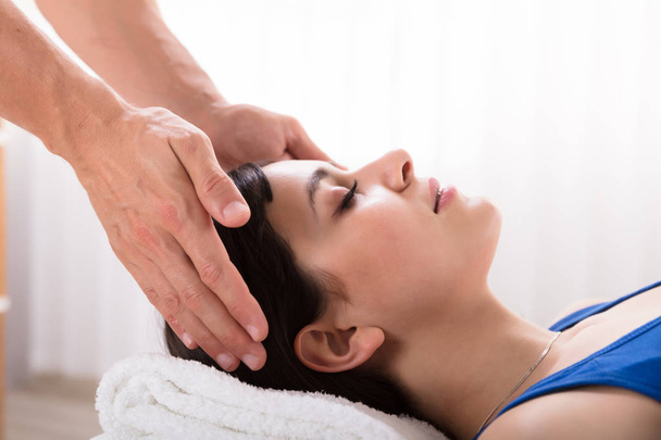 Close-up Of Therapist's Hand Performing Reiki Treatment On Young Woman In Spa - Photo, image