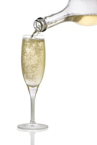 en una copa verter champán de una botella sobre un fondo blanco
 - Foto, Imagen