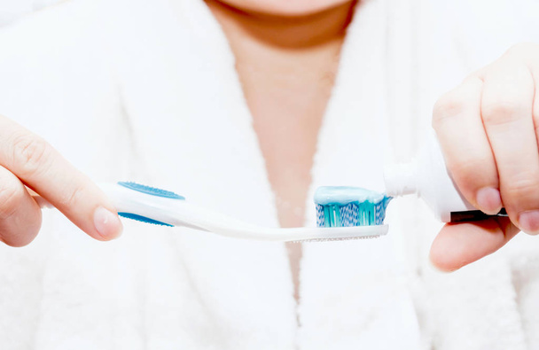 Woman applying toothpaste on toothbrush - Photo, Image