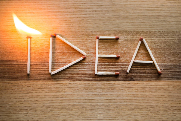 Слово проекта IDEA из спичек с пламенем на деревянном фоне
 - Фото, изображение