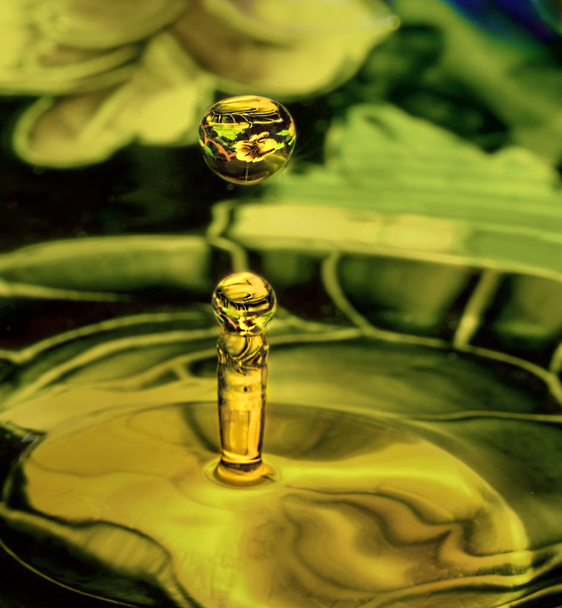İki şeffaf su damla çevreleyen yeşil ve sarı çiçek desenli yansıtan. Sıvı damla sanat, su damla fotoğraf - Fotoğraf, Görsel