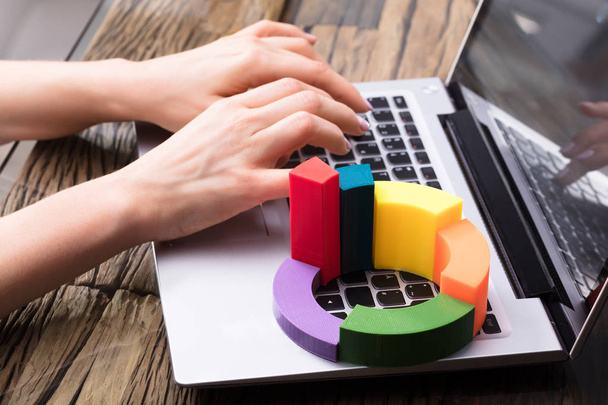 Femme d'affaires utilisant un ordinateur portable avec un graphique à secteurs 3d multicolore
 - Photo, image