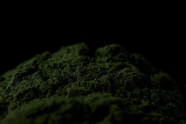 επιλεκτική εστίαση σπιρουλίνα φύκια σε σκόνη που απομονώνονται σε μαύρο φόντο  - Φωτογραφία, εικόνα