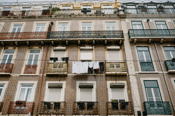 Authentic photography. Clothes dry on the facade of an apartment building in Lisbon in Portugal. The characteristic feature of the Portuguese is everywhere to hang out clothes and linen to dry. - Photo, Image