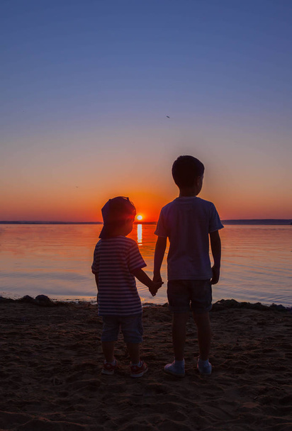 Dois meninos irmãos assistir o pôr do sol bonito
. - Foto, Imagem