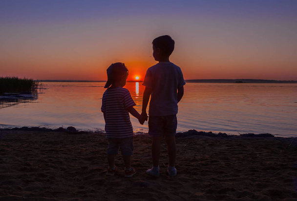Two boys brothers watch the pretty sunset. - Photo, Image