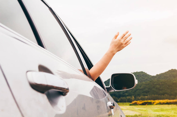 Nő kezét az autó kellemes és boldog utas hegyi háttér - Fotó, kép
