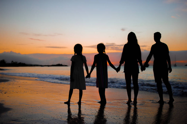 Silhouette familiale au coucher du soleil sur la plage
 - Photo, image