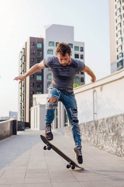 Skateboarder doing a skateboard trick ollie on the street of a city - Fotoğraf, Görsel