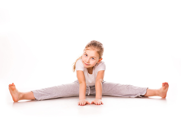 Beautiful girl gymnast exercising, stretching - Valokuva, kuva